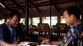 Two priests in colorful shirts sharing together inside the hall